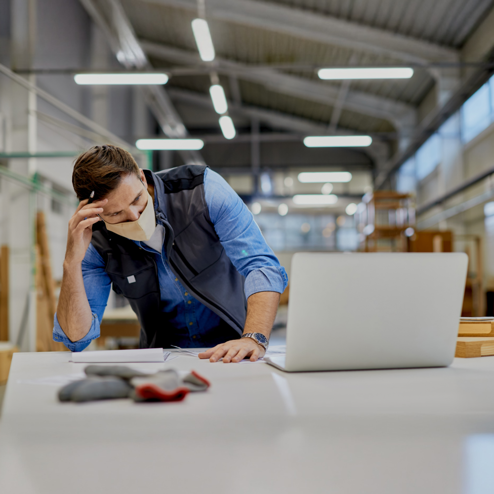 Freight forwarder stressed while facing operational challenges and unreliable logistics partners in a warehouse office environment